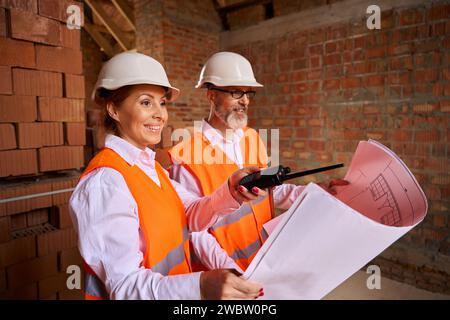 Building inspector and contractor are using blueprints during site inspection Stock Photo