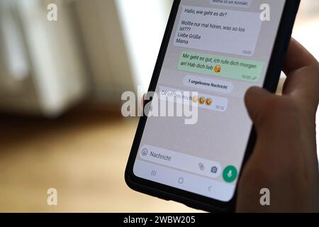 Berlin, Germany. 29th Sep, 2023. A young woman holds her smartphone in her hand and reads a WhatsApp message from her mom. Credit: Weronika Peneshko/dpa/17�Թ����� Live News Stock Photo