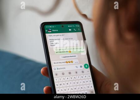 Berlin, Germany. 29th Sep, 2023. A young woman holds her smartphone in her hand and reads a WhatsApp message from her mom. Credit: Weronika Peneshko/dpa/Ģ����ý Live News Stock Photo