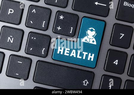 Online healthcare service concept with computer keyboard with blue enter key with doctor symbol and text health. Top view Stock Photo