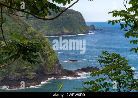 Captivating coastal cliffs line the route to Hana, Maui, offering stunning views of the Pacific amidst vibrant tropical foliage. Stock Photo