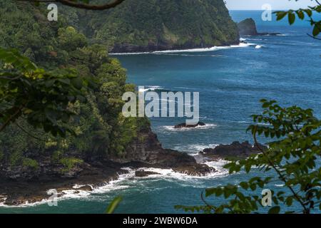 Captivating coastal cliffs line the route to Hana, Maui, offering stunning views of the Pacific amidst vibrant tropical foliage. Stock Photo