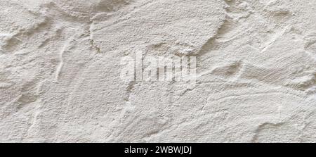 The rough texture of a poorly plastered light-colored wall. An uneven surface with bumps and depressions. Background for the design. Full frame. Copy Stock Photo