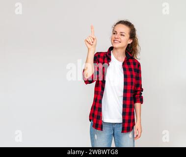 Mockup background of cheerful woman touching virtual projection screen with her finger. Online shopping. eBanking virtual service. Select a product in Stock Photo