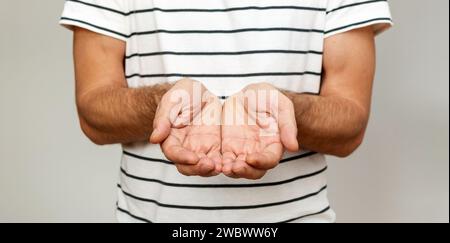 Male person holding hands with palms up. Stock Photo