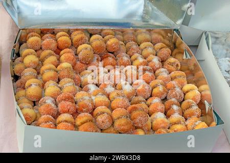 Small sweet donuts sprinkled with sugar sold outside on a market Stock Photo