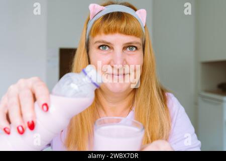 Middle aged woman drinking yogurt Stock Photo