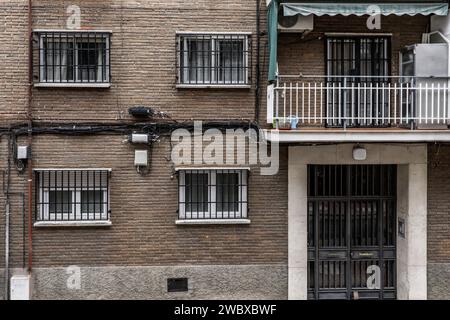 Facade of a conventional urban residential housing building with anti-theft bars on the windows Stock Photo