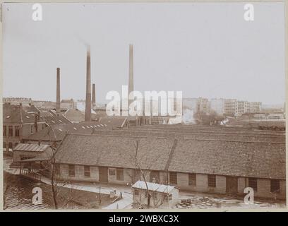 Exterior of factory buildings with chimneys, in the foreground wooden barrels, anonymous, c. 1900 - c. 1910 photograph Part of Family Album with photos of Wijnhandel Kraaij & Co. Bordeaux-Amsterdam.  photographic support  factory-building. smoke-stack Stock Photo