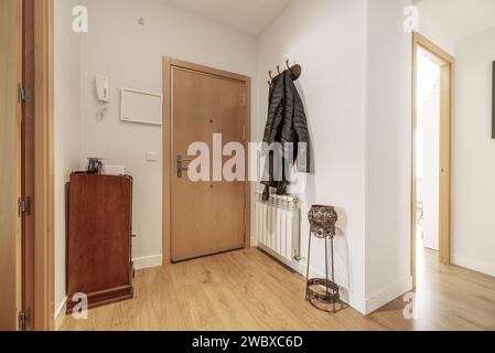 Hallway of a home with armored access door and a coat rack with hanging clothes Stock Photo