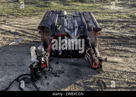 Remains of a dismantled vehicle abandoned in the middle of the countryside Stock Photo