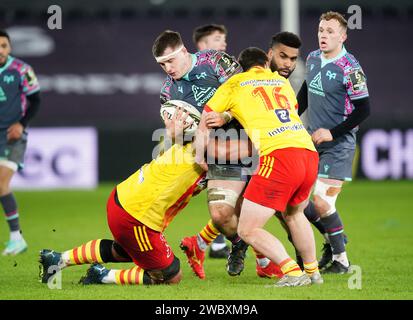 Ospreys' Morgan Morse (centre) is tackled by USA Perpignan's Sootala Faasoo (left) and Victor Montgaillard during the EPCR Challenge Cup match at the Swansea.com Stadium, Swansea. Picture date: Friday January 12, 2024. Stock Photo