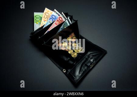 closeup of a black waiter and german taxi driver purse or wallet, small or loose change coins of Euros and Cents, one 5, 10, 20, 50 and 100 Euro bill Stock Photo