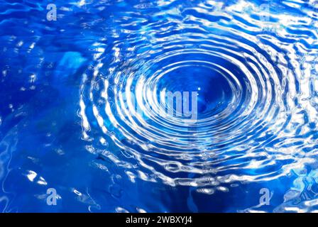 closeup, macro of a small water vortex or swirl, causing circular waves on the surface, seen from above the surface Stock Photo