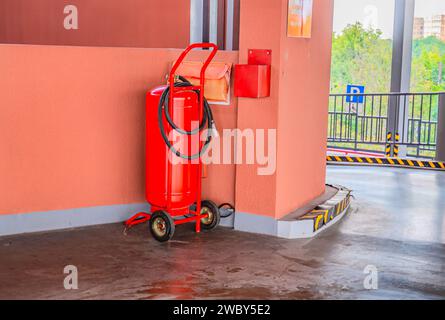 fire extinguishers available in fire emergencies. Red fire extinguisher on hand truck at gas station ready for use Stock Photo