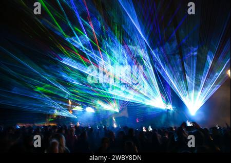 Multicolored light show at night. Laser lights and fog on the stage during concert. Laser beams on festival. Abstract background. Stock Photo