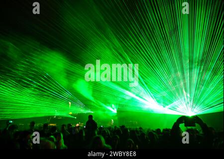 Multicolored light show at night. Laser lights and fog on the stage during concert. Laser beams on festival. Abstract background. Stock Photo