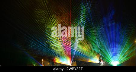 Multicolored light show at night. Laser lights and fog on the stage during concert. Laser beams on festival. Abstract background. Stock Photo