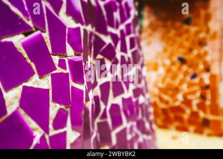 Multicolored violet and orange ceramic mosaic details. Colorful artwork abstract background. Architecture decoration. Mosaics wall surface. Stock Photo
