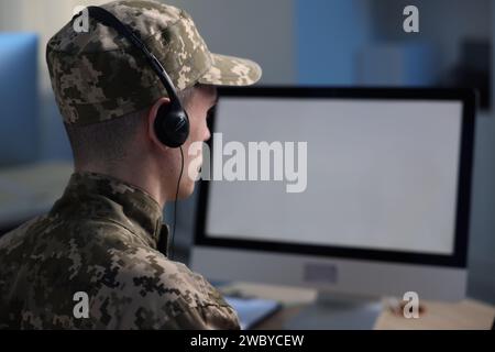 Military service. Soldier in headphones working in office, space for text Stock Photo