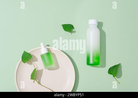 Minimal scene of empty label beauty containers decorated with fish mint leaves. Research and development beauty skincare concept Stock Photo