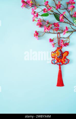 A dragon pendant hanging at pink chinese blossom tree on blue background for Chinese new year concept. Stock Photo