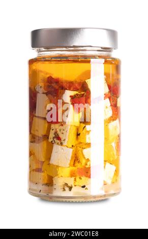 Feta cubes in oil, with red pepper and chili pieces, in glass jar. Greek cheese, matured in brine, cut in block shape, preserved in spiced oil. Stock Photo