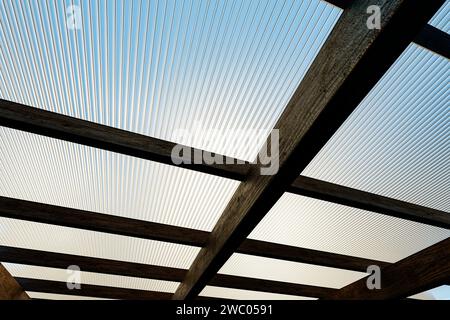 Wooden canopy roof structure made of colored polycarbonate. Stock Photo