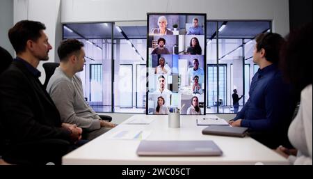 Businesspeople Sitting In A Conference Room Looking At Computer Screen Stock Photo