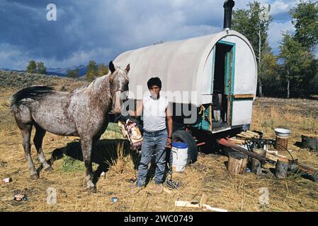 Peruvian shepherd with his horse standing outside his sheep wagon in Blaine County, Idaho Stock Photo