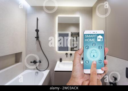 Female hands holding phone with app smart home screen in room house Stock Photo