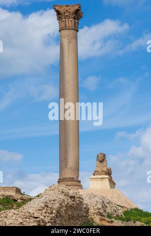 Sphinx and giant ancient Pompey's pillar on territory of Serapeum of Alexandria in Egypt Stock Photo