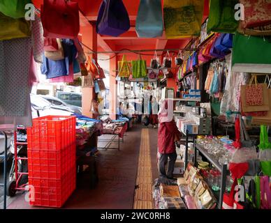 Shop houses in old Bandung City on Jl. Cibadak in West Java, Indonesia with covered paved area where many goods such as bags are displayed for sale. Stock Photo