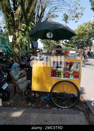 Indonesian Street Food Cart of Gerobak in Bandung, West Java, Indonesia selling fresh tropical fruit. Stock Photo
