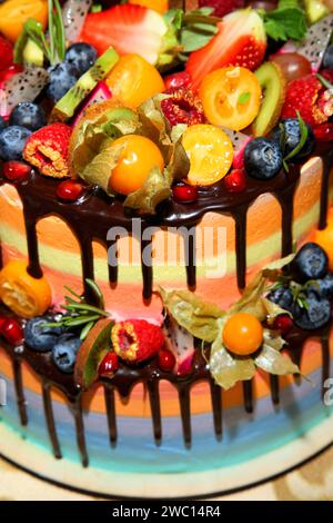 Delicious children's fruit cake with fresh strawberries, raspberries, blueberries, currants, kiwi, pomegranate . Stock Photo