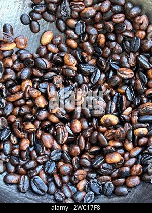 coffee beans being roasted by hand in the traditional way on a wood-fired stove. Stock Photo