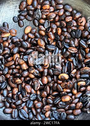 coffee beans being roasted by hand in the traditional way on a wood-fired stove. Stock Photo