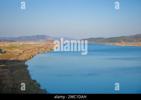 Sangju City, South Korea - November 18th, 2023: An expansive view of the wide Nakdong River, with adjacent farm fields and low hills in the distance, Stock Photo