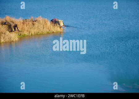 Sangju City, South Korea - November 18th, 2023: Along the Nakdong River, the majority of the picture is water, bordered by high reeds and camouflaged Stock Photo