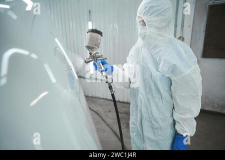Master paints the hood of a car with white paint Stock Photo