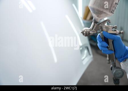 Modern apparatus for painting a car in hands of master Stock Photo