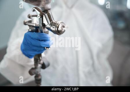 Person with a paint injection tank in his hands Stock Photo