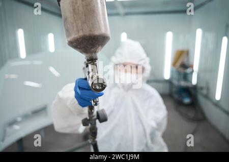 Woman with a paint injection tank in her hands Stock Photo