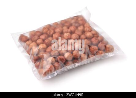 Raw shelled hazelnuts in transparent plastic bag isolated on white Stock Photo