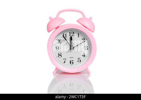 pink alarm clock set twelve o'clock isolated over white background close-up Stock Photo