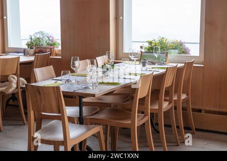 Wooden dining table set with glassware and silverware in restaurant Stock Photo