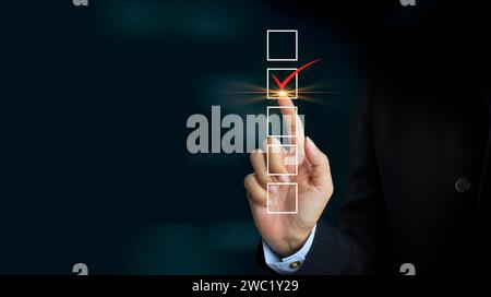 Checklist and Quality Assurance Concept. Businessman marks on check box with white check mark Stock Photo