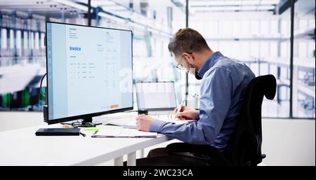 Businessperson Analyzing Invoice On Computer In Office Stock Photo