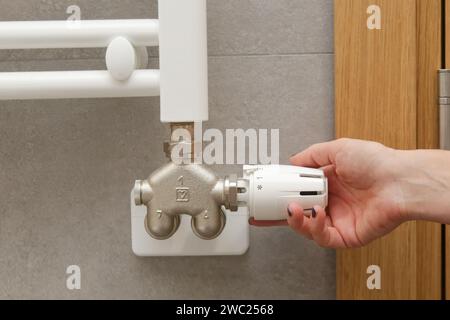 Woman's hand adjusting radiator thermostat valve, controlling central heating system Stock Photo