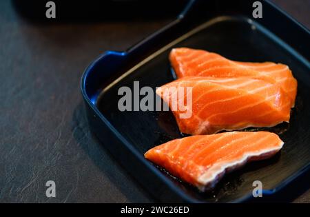 sliced salmon on black dish and black background. Japanese food concept Stock Photo